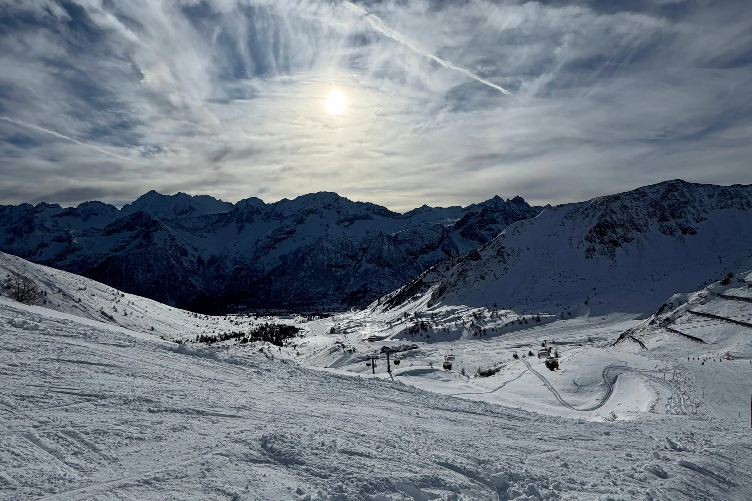 Il Passo del Tonale d'inverno: la conca innevata con le piste battute, gli impianti di risalita e le cime sullo sfondo
